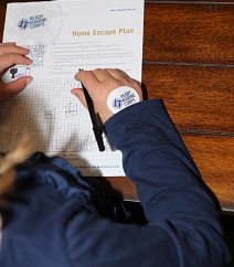 A young girl completes the home escape plan worksheet.