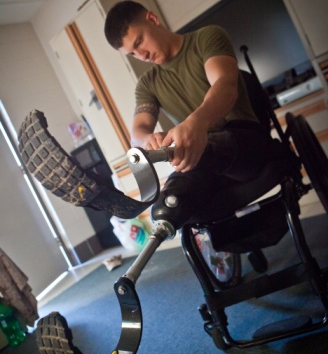 A wounded Marine affixes a prosthetic leg in this image.